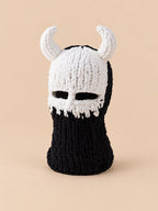 Cagoule crochet cornes de diable modèle 5 noire et blanche, vue de face sur fond pêche sable