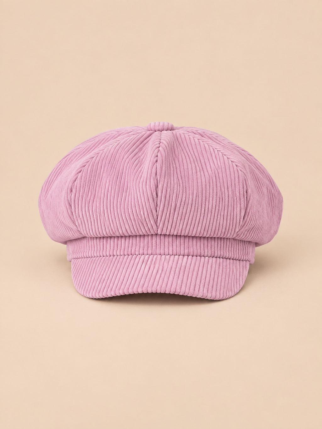 Gorra gavroche de ocho paneles, estilo boina vintage, color rosa, vista frontal, sobre fondo color arena y melocotón