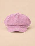 Gorra gavroche de ocho paneles, estilo boina vintage, color rosa, vista frontal, sobre fondo color arena y melocotón