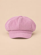 Gorra gavroche de ocho paneles, estilo boina vintage, color rosa, vista frontal, sobre fondo color arena y melocotón