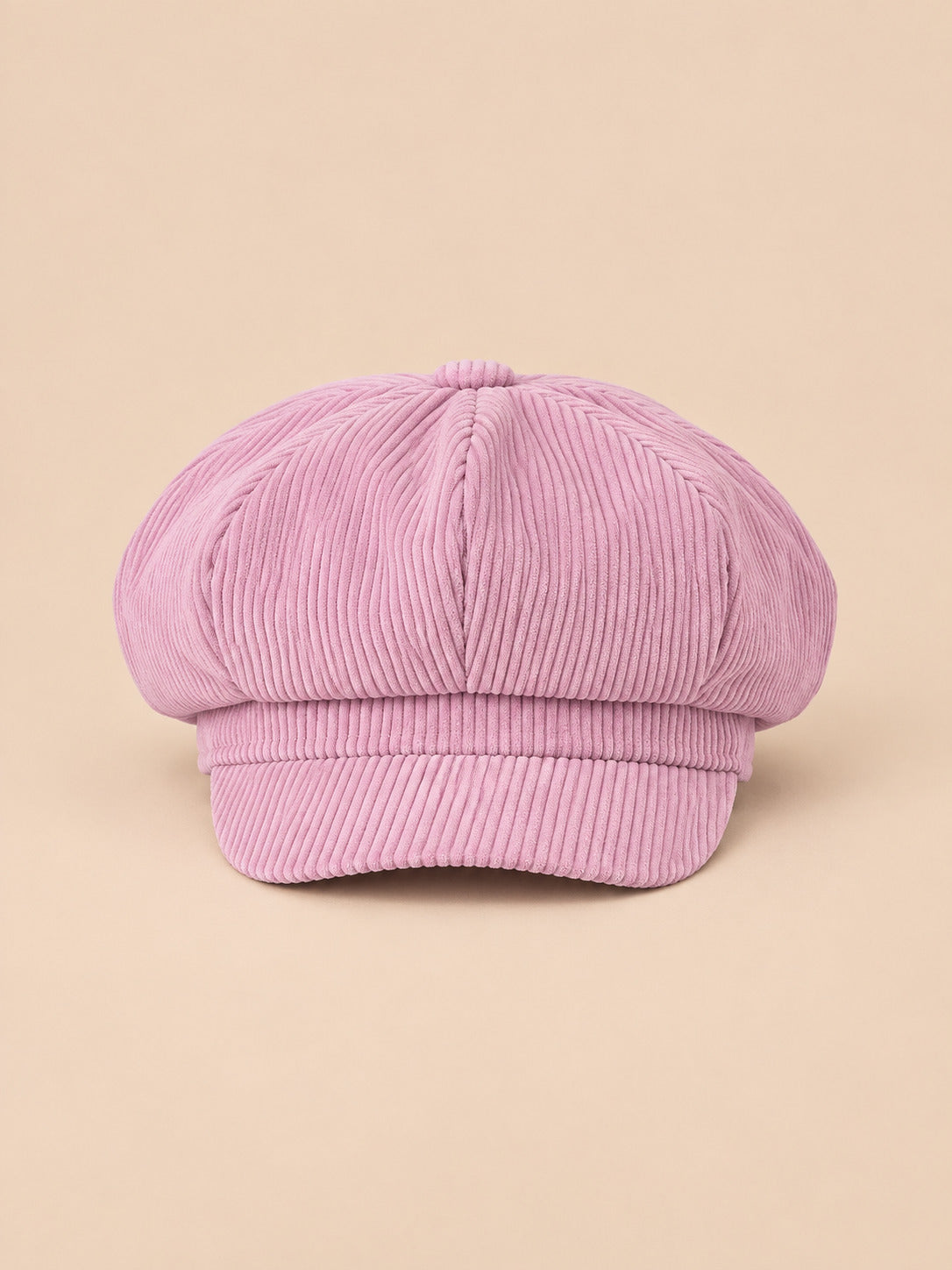 Casquette gavroche octogonale en velours côtelé rose fonce, vue de face sur fond pêche sable