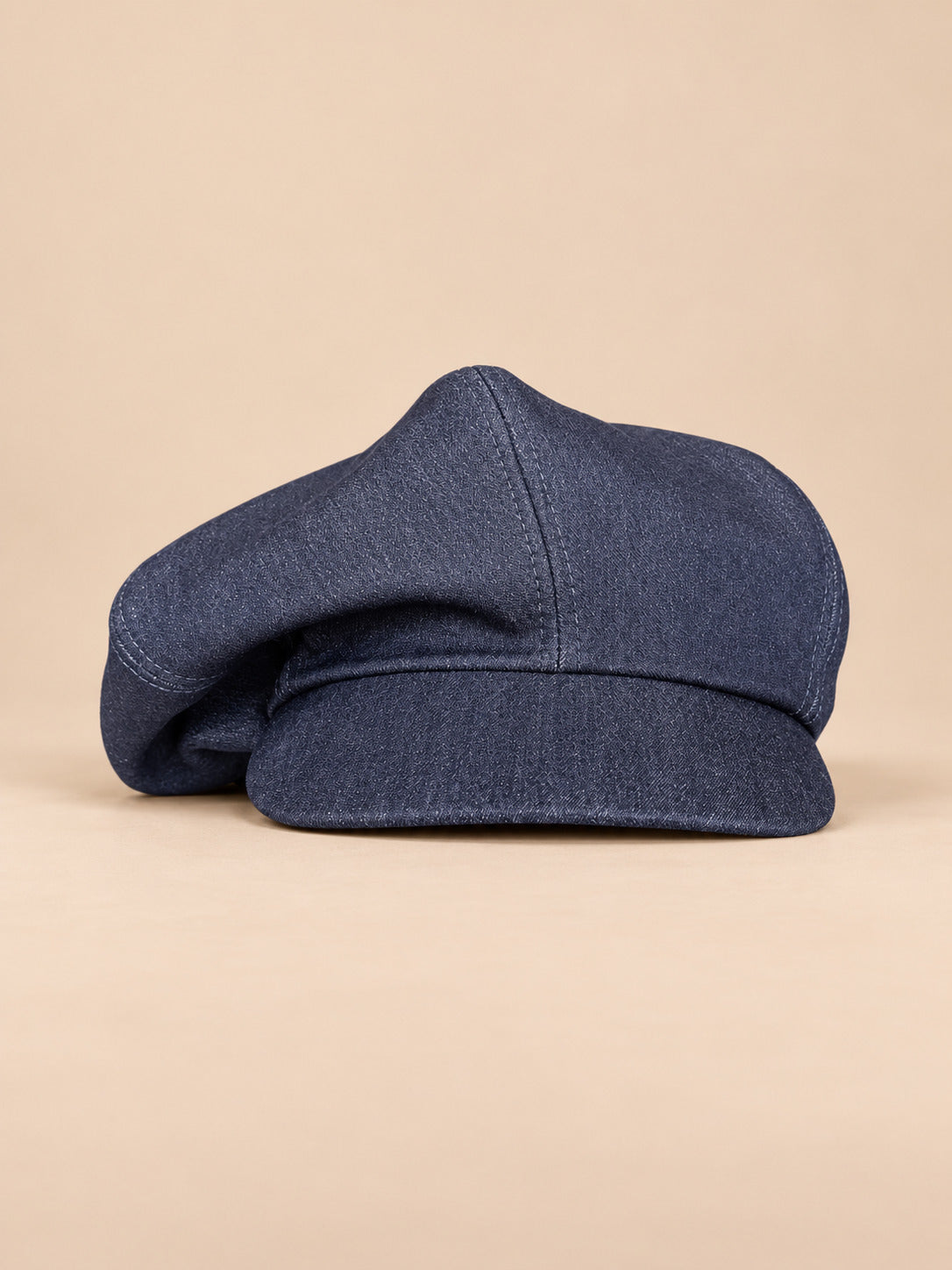 Gorra gavroche vintage de algodón con pata de gallo, color azul, vista frontal, sobre fondo color arena y melocotón