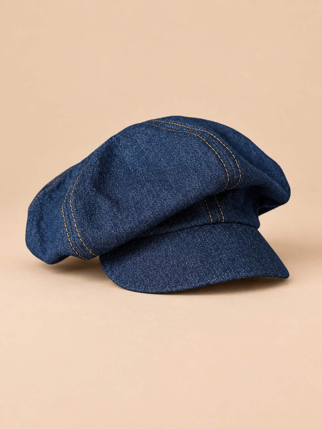Gorra gavroche vintage de algodón con pata de gallo, color gris, vista frontal, sobre fondo color arena y melocotón