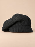Gorra gavroche vintage de algodón con pata de gallo, color negro, vista frontal, sobre fondo color arena y melocotón