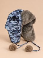 Gorro aviador gótico multicolor con motivo de camuflaje, calavera y pompones, visto de tres cuartos