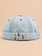 Bonnet docker en denim bleu clair, revers effiloché à détails léopard, vue de face.