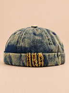 Bonnet docker en denim jaune, revers effiloché à détails léopard, vue de face.