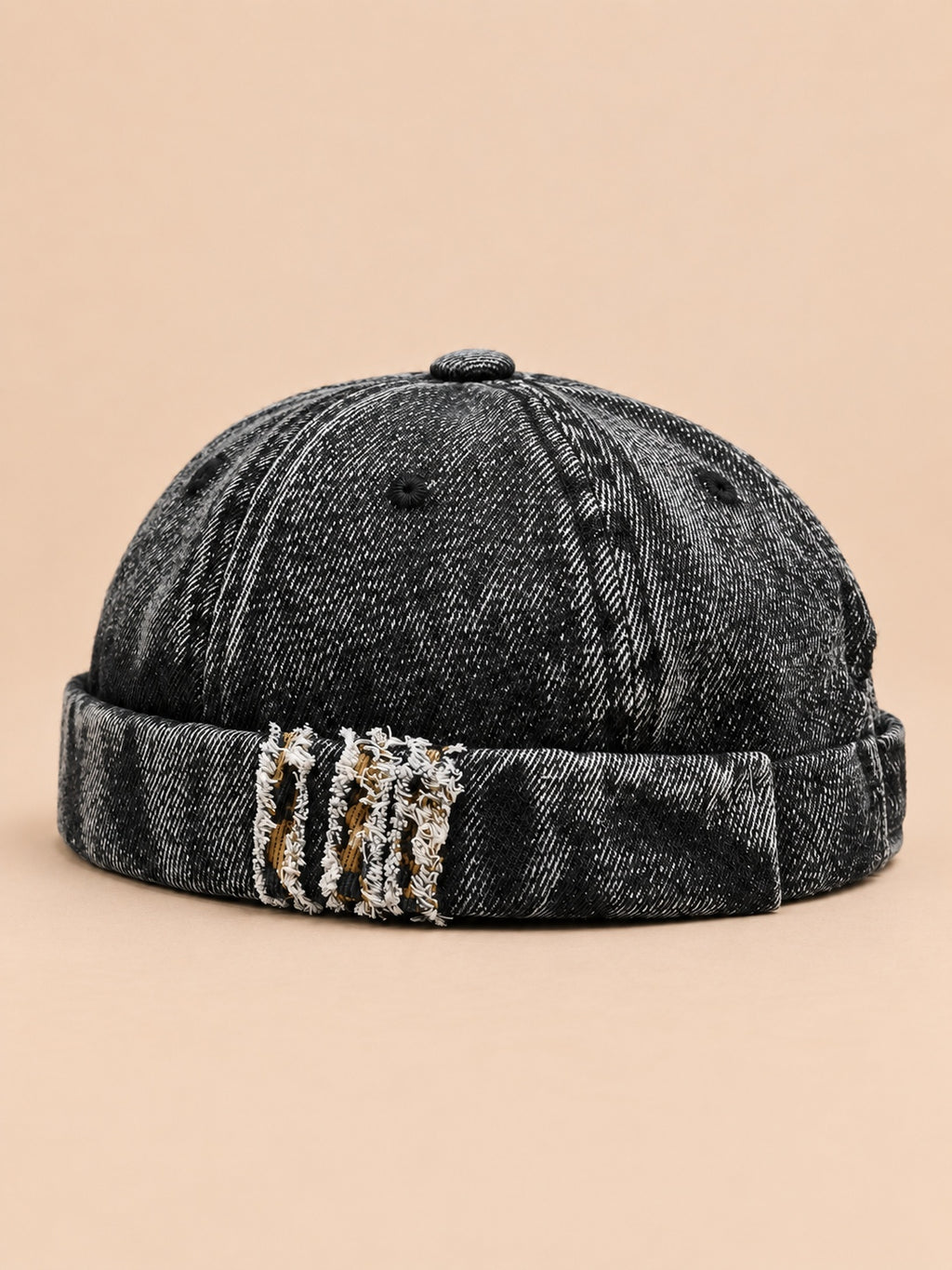 Bonnet docker en denim noir, revers effiloché à détails léopard, vue de trois quarts.