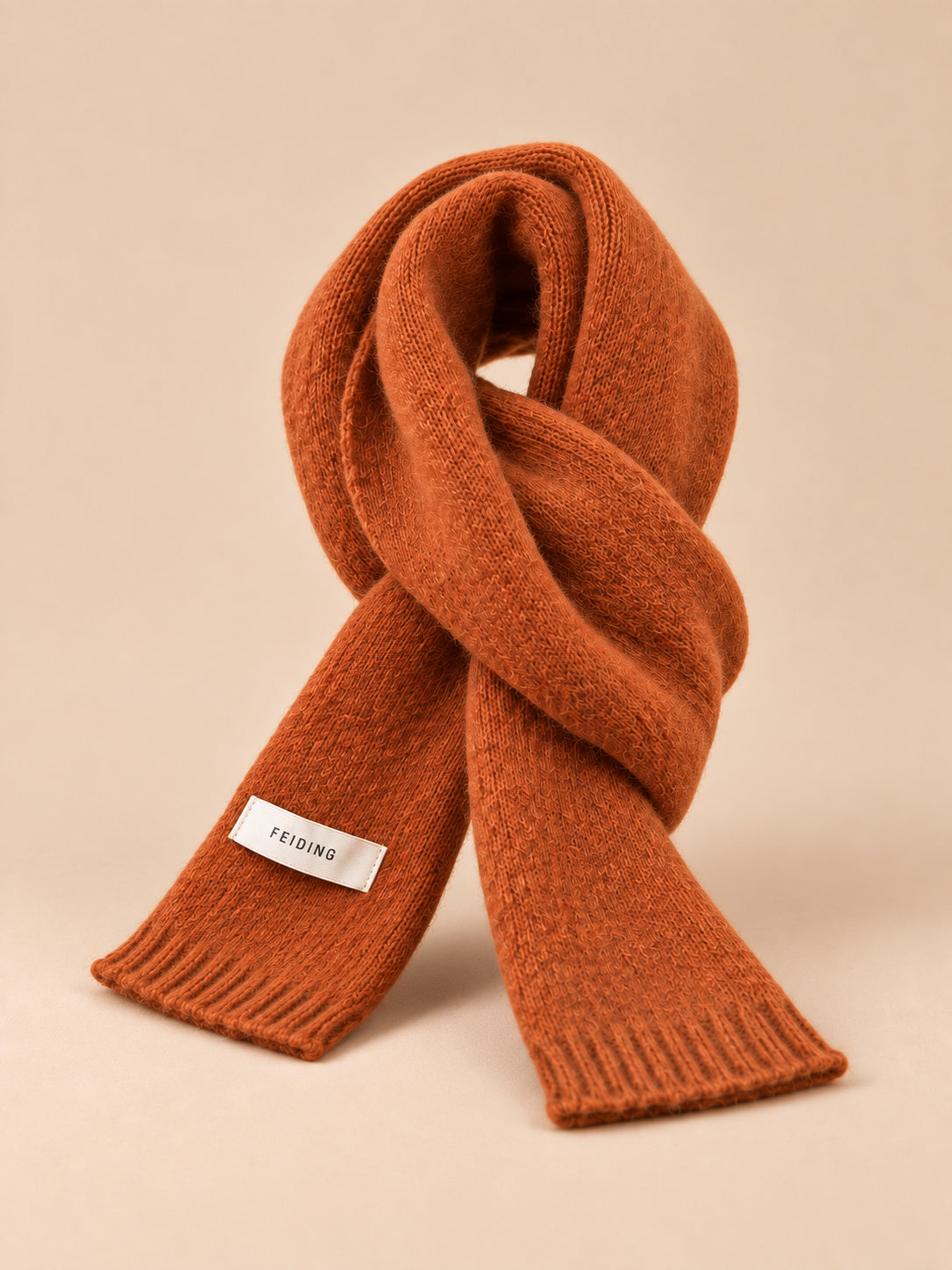 Écharpe unie classique, orange, vue de trois quarts sur fond pêche sable.