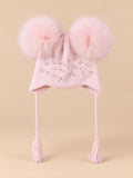 Gorro rosa infantil con dos pompones de pelo de mapache del mismo color, fotografiado de frente