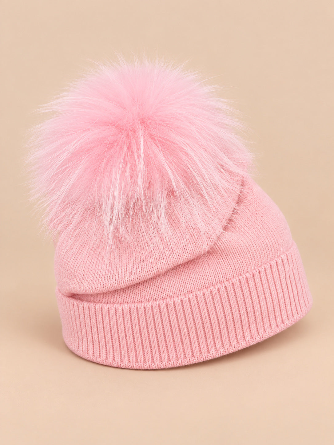 Bonnet enfant rose pompon assorti en maille à revers, vue de trois quarts