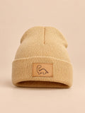 Gorro infantil con vuelta y parche de dinosaurio, color camel, vista frontal en la fotografía del producto