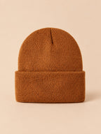 Bonnet enfant caramel en maille, vue de face, fond pêche sable