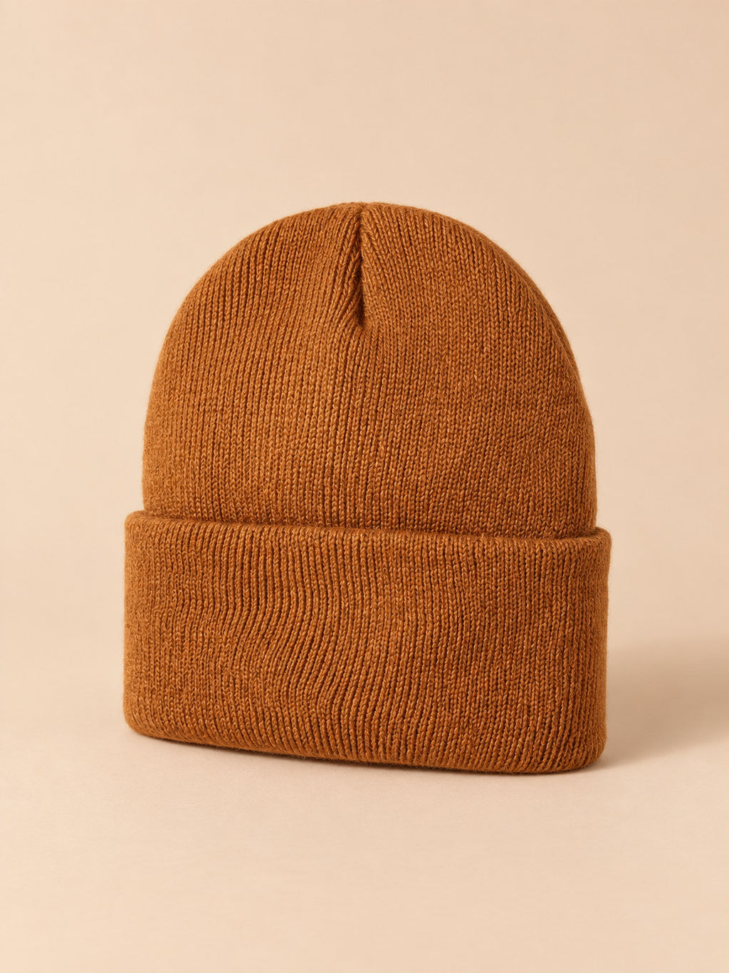 Bonnet enfant caramel en maille, vue de trois quarts, fond pêche sable