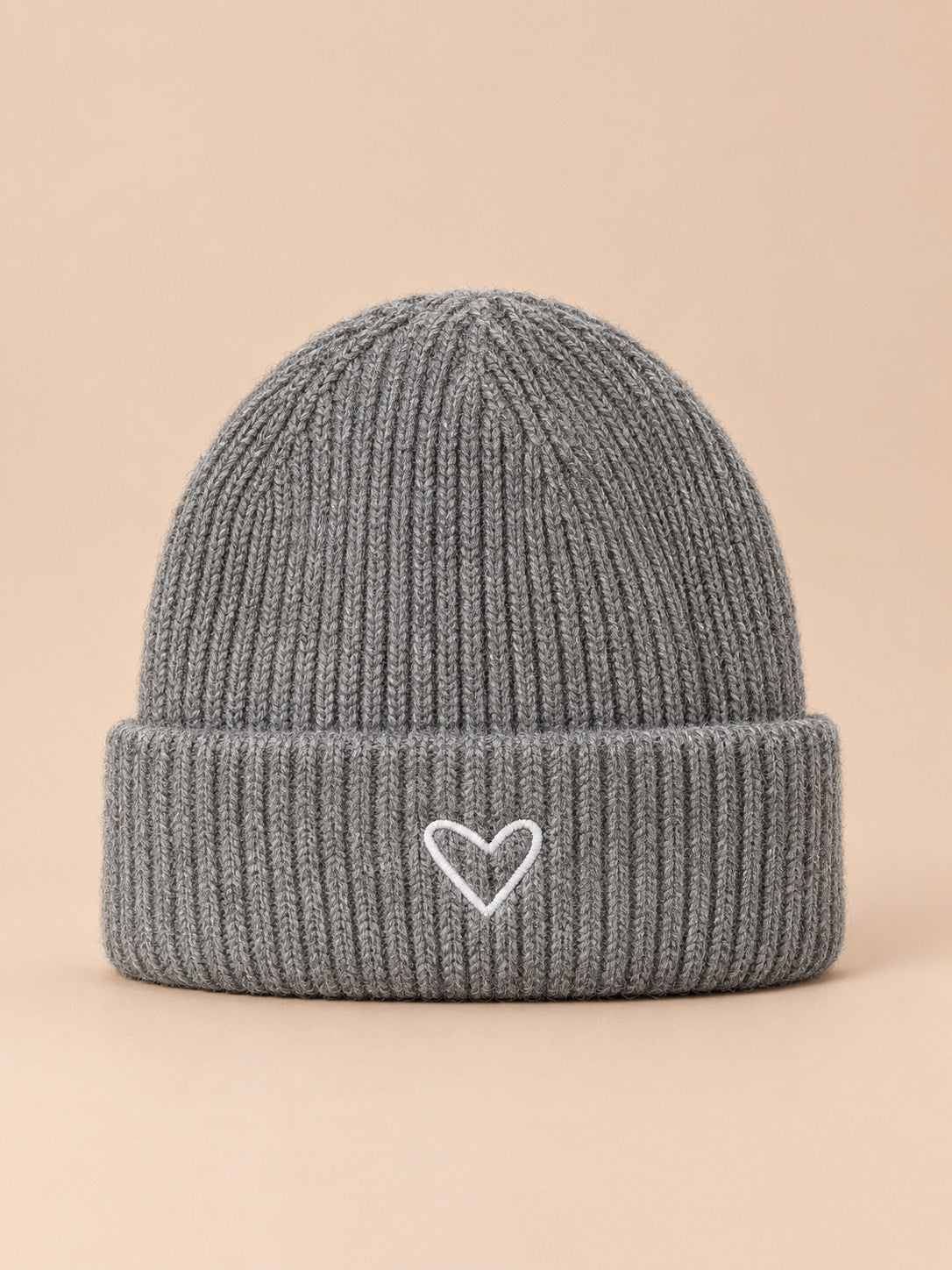 Bonnet enfant gris en maille, vue de face, fond pêche sable