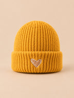 Bonnet enfant jaune en maille, vue de face, fond pêche sable