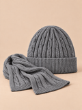 Conjunto de gorro y bufanda de lana gruesa jacquard, color gris, vista frontal, sobre fondo color arena y melocotón