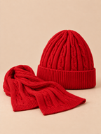 Ensemble bonnet à revers et écharpe en laine jacquard rouge, vue de trois quarts sur fond pêche sable.