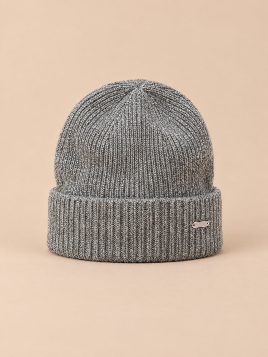 Bonnet côtelé en laine mélangée, coloris 1 gris, vue de face sur fond pêche sable