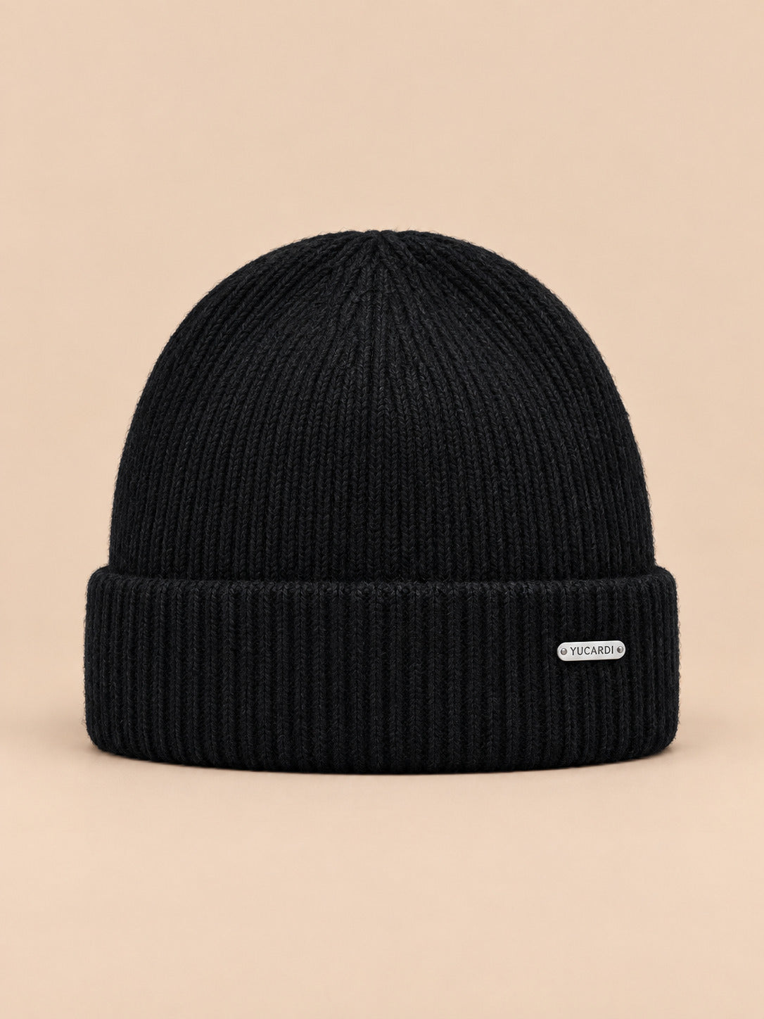 Bonnet côtelé en laine mélangée, coloris 5 noir, vue de face sur fond pêche sable