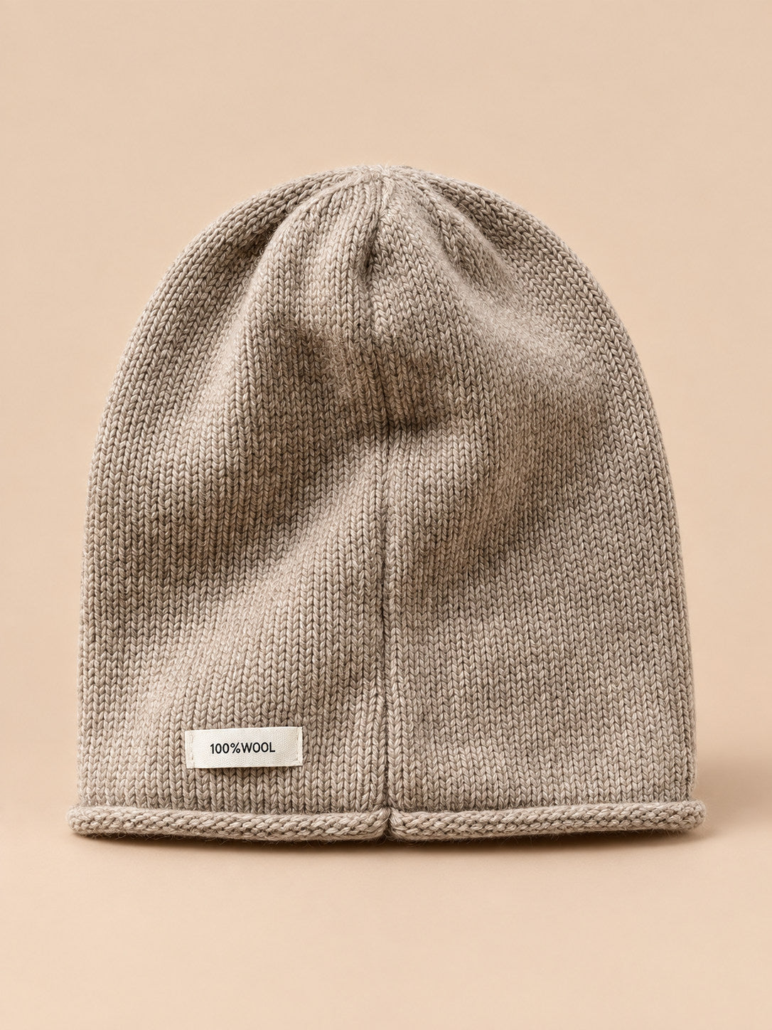 Bonnet femme en pure laine kaki, vue de face, fond pêche sable
