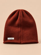 Bonnet femme en pure laine rouge, vue de face, fond pêche sable