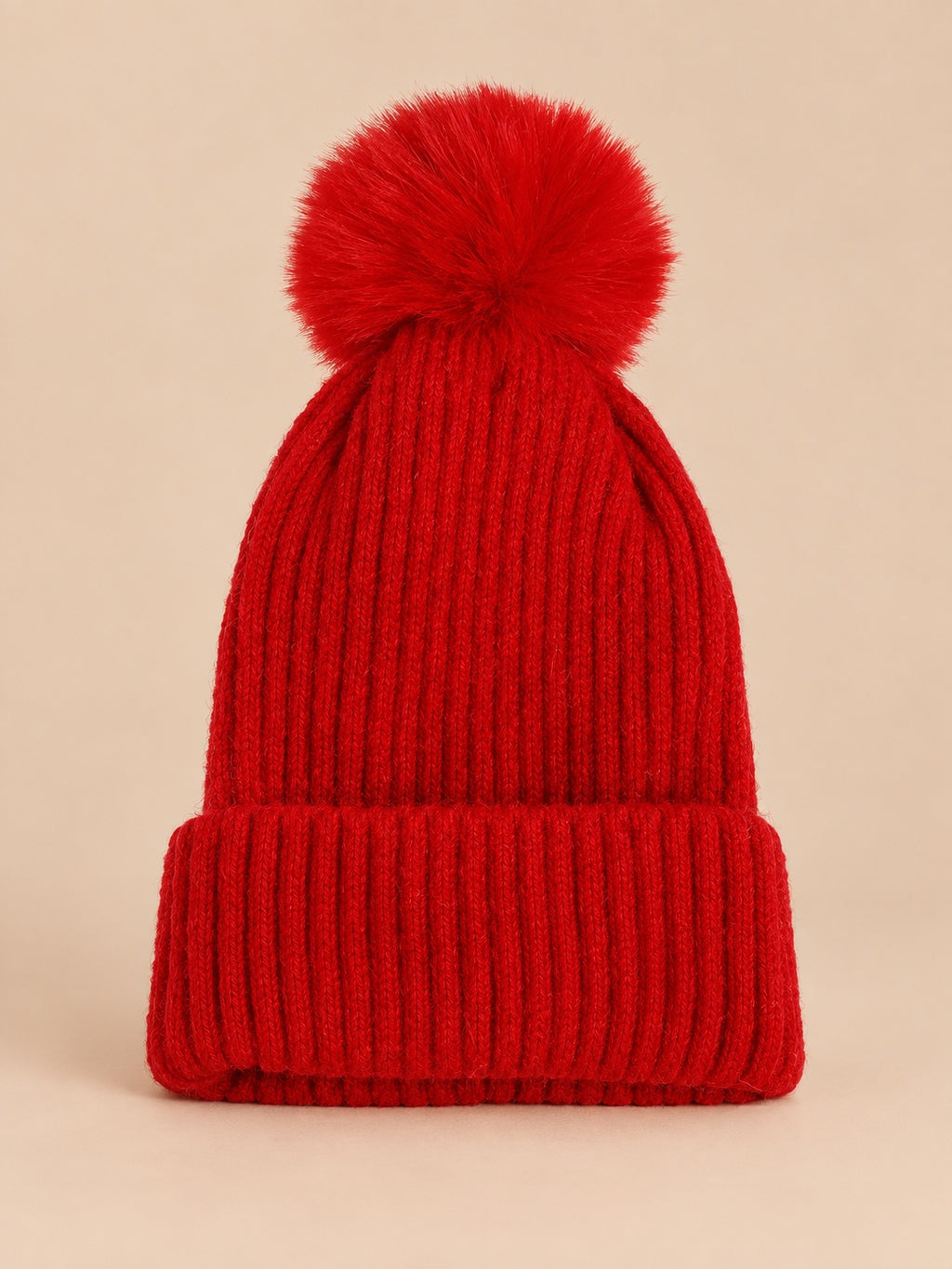 Bonnet de ski rouge sans logo, maille côtelée à revers et gros pompon assorti, vue de face.