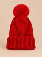 Bonnet de ski rouge sans logo, maille côtelée à revers et gros pompon assorti, vue de face.