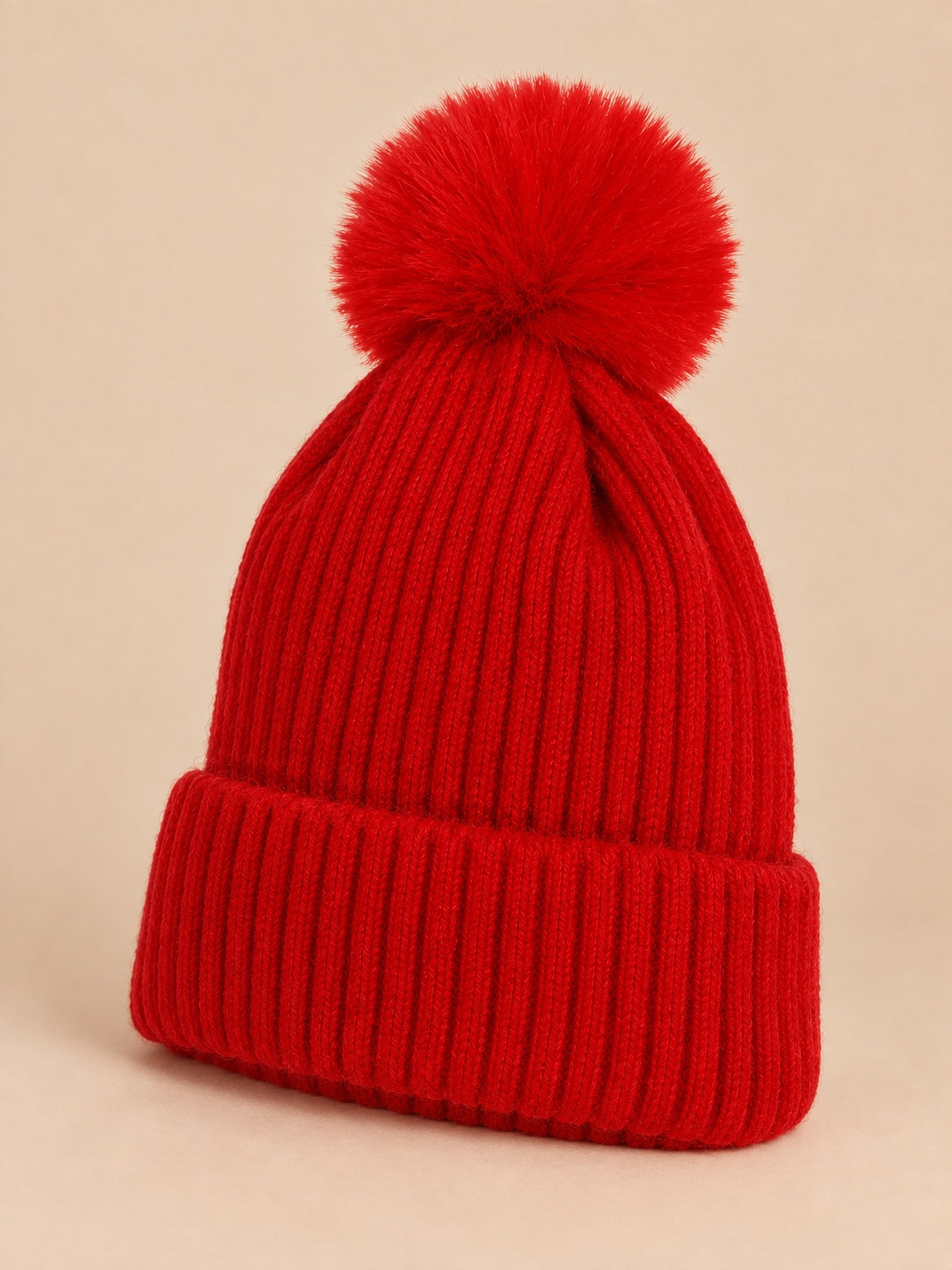 Bonnet de ski rouge sans logo à gros pompon et revers côtelé, vue de trois quarts.