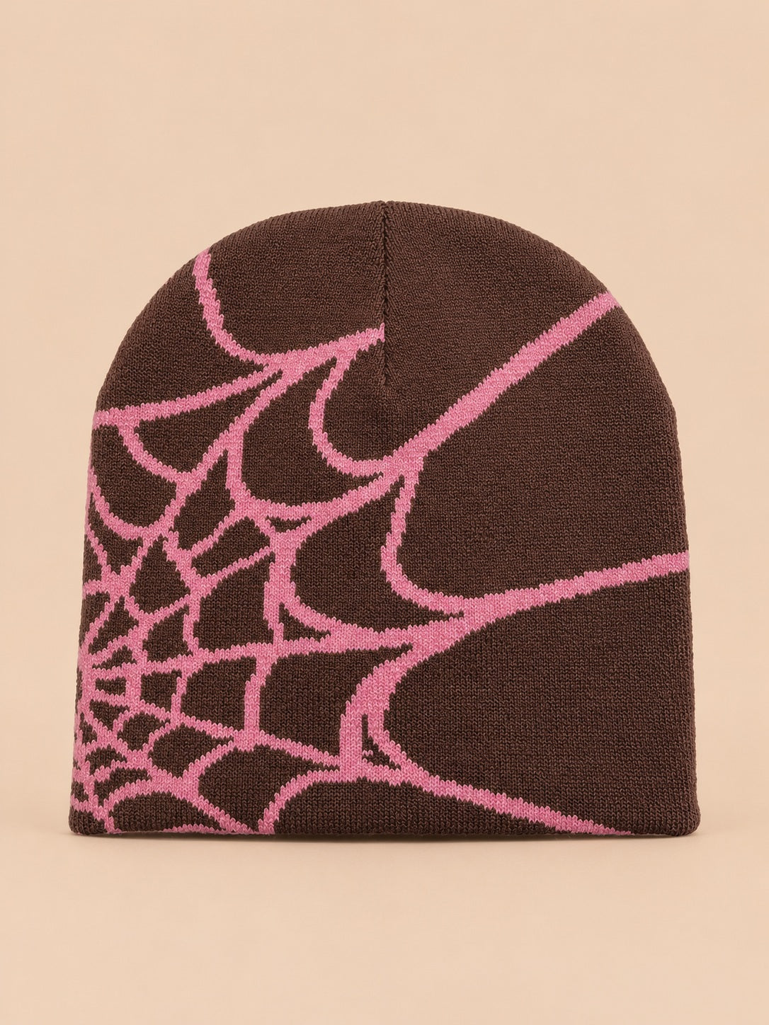 Bonnet motif toile d'araignée café à toile rose, vue de face sur fond pêche sable