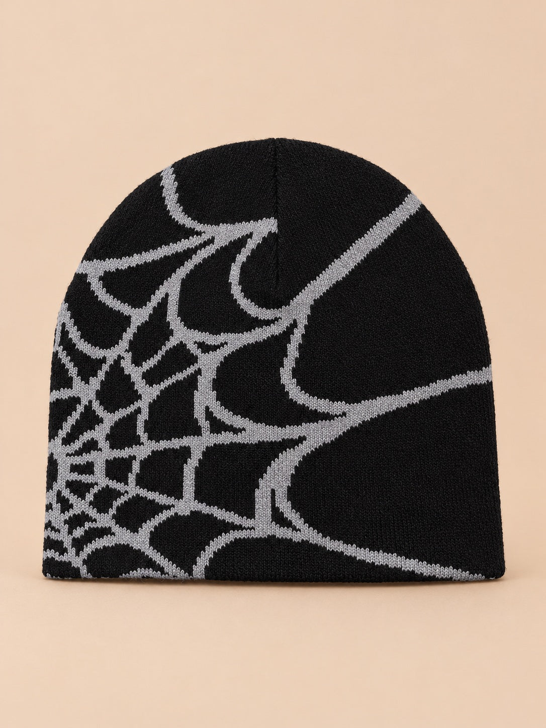 Bonnet motif toile d'araignée noir à toile grise, vue de face sur fond pêche sable