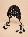 Gorro de pescador negro con flores caladas y forma flexible que envuelve la cabeza, visto de frente