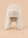 Gorro peruano de mujer blanco marfil con orejeras y cintas para anudar, fotografiado de frente