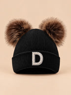 Gorro negro de mujer de tejido polar con letra D y orejas decorativas suaves, fotografiado de frente