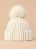 Bonnet à pompon blanc en maille côtelée à revers, vue de face.