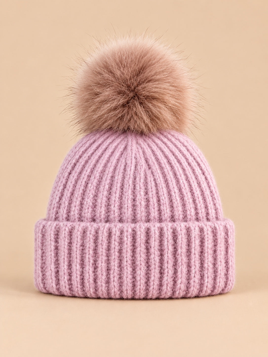 Bonnet à pompon rose en maille côtelée à revers, vue de face.