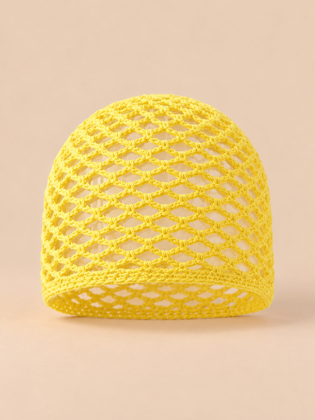 Bonnet fin femme jaune poussin en coton résille ajouré, vue de face sur fond pêche sable
