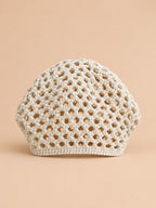 Gorro beige de rejilla con canalé fino y estructura aireada de estilo retro, fotografiado de frente