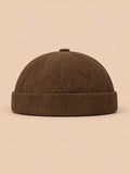 Gorro sin ala de pana a rayas para entretiempo, color caqui, vista frontal, sobre fondo color arena y melocotón