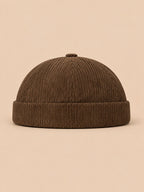 Gorro sin ala de pana a rayas para entretiempo, color caqui, vista frontal, sobre fondo color arena y melocotón