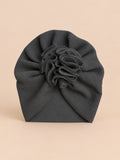 Gorro turbante de recién nacida con flor, color negro, vista frontal en la fotografía del producto