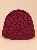 Bonnet turban femme bordeaux ajouré à fleurs au crochet, vue de face sur fond pêche sable