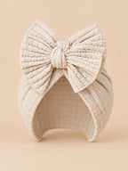 Turbante para recién nacida de algodón de punto con nudo, variante beige claro, visto de frente