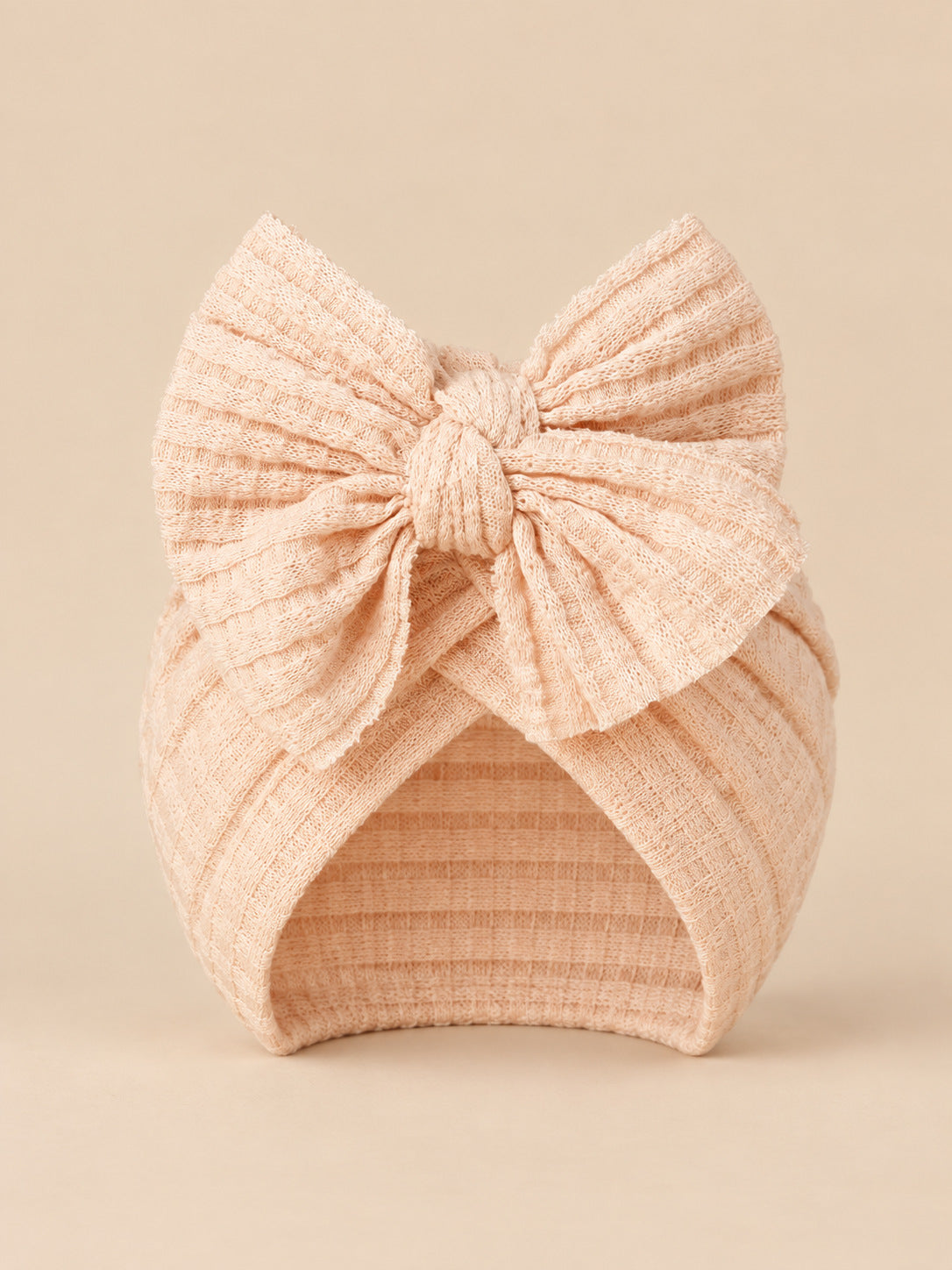 Bonnet turban bébé fille en coton tricoté rose pêche, nœud, vue de face