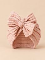 Gorro turbante de bebé niña de punto de algodón con lazo, color rosa empolvado, vista frontal