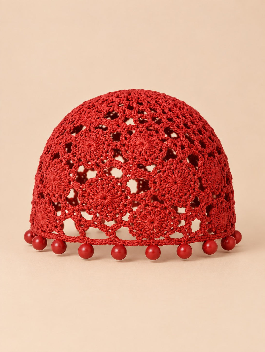 Turbante rojo sin borde efecto ganchillo, con perlas decorativas y punto aireado, fotografiado de frente