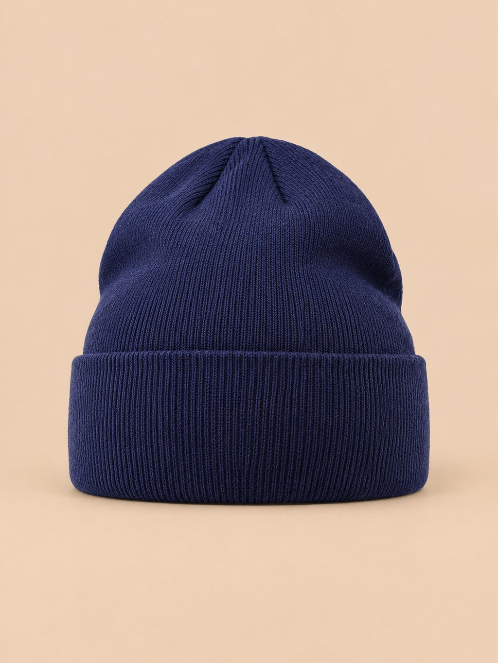 Gorro liso clásico de punto suave y ligero, color azul marino, vista frontal, sobre fondo color arena y melocotón